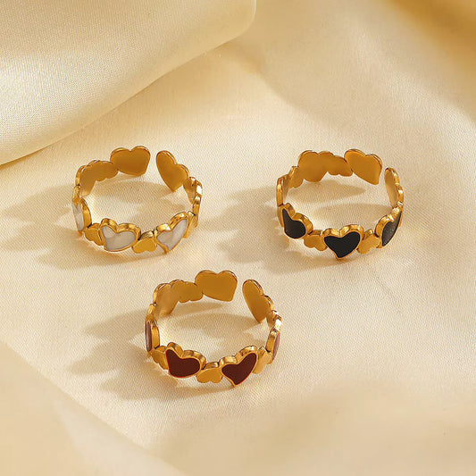 Set of 3 gold heart rings with white, red and black enamel hearts on cream silk